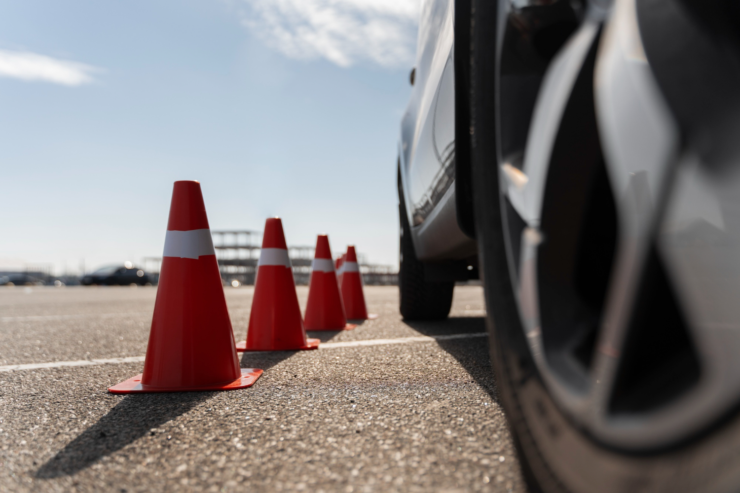 Driving-test cones beside a car on a practice course